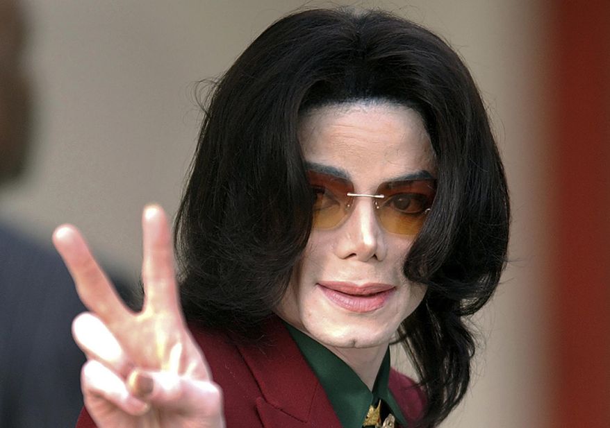 Pop star Michael Jackson acknowledges his fans as he arrives at the Santa Barbara County Courthouse, in Santa Maria, Calif., March 17, 2005. Jackson was acquitted in 2005 of molesting a 13-year-old cancer survivor at his Neverland Ranch. (AP Photo/Michael A. Mariant, File)