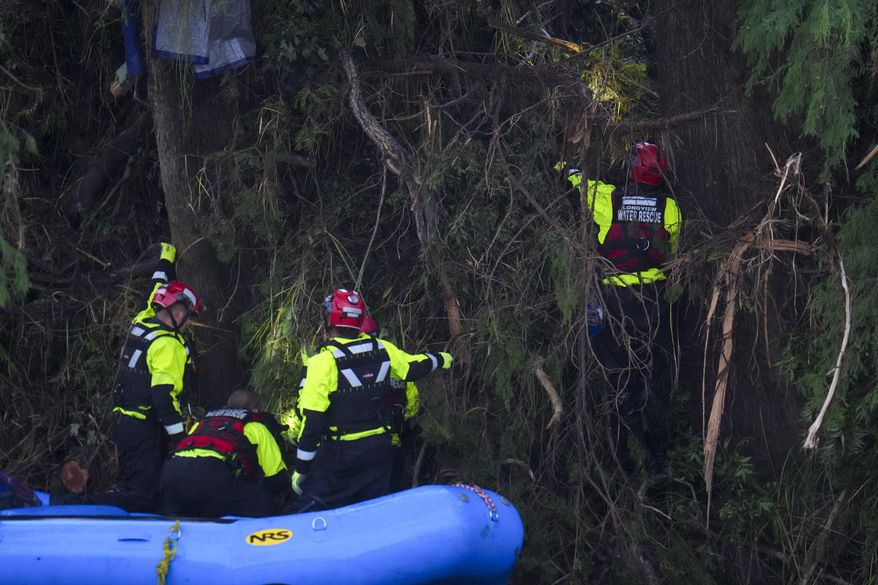 Officials assist with a recovery effort at Camp Mystic along the Guadalupe River after a flash flood swept through the area Sunday, July 6, 2025, in Hunt, Texas. (AP Photo/Julio Cortez)