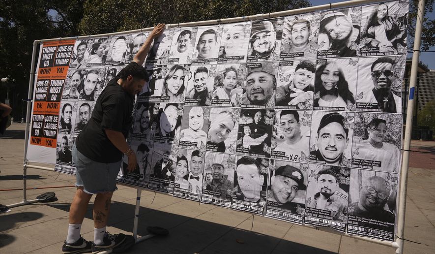 A volunteer sets up an art installation displaying names and faces of people who have been detained, deported, or sent to offshore camps during ICE raids in Southern California, at Olvera Street Plaza in Los Angeles, on Thursday, July 3, 2025. (AP Photo/Damian Dovarganes)