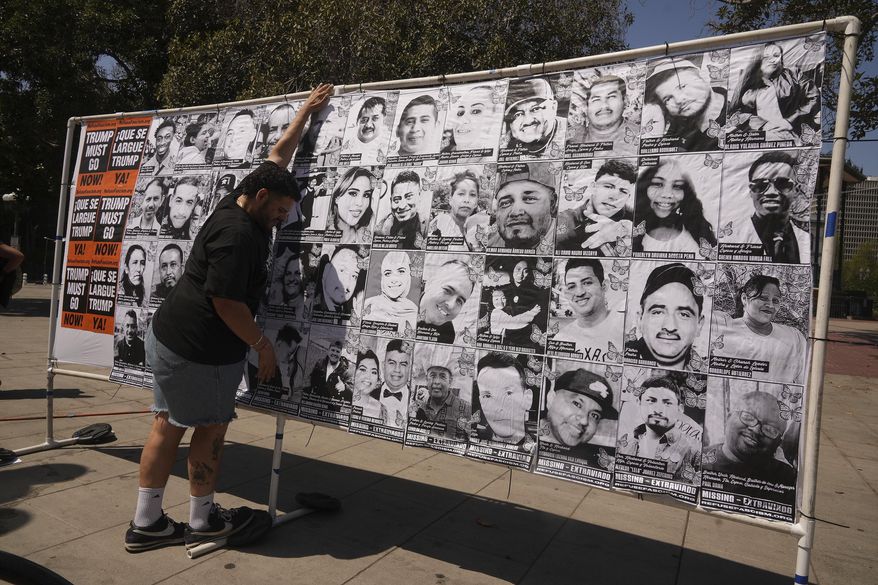 A volunteer sets up an art installation displaying names and faces of people who have been detained, deported, or sent to offshore camps during ICE raids in Southern California, at Olvera Street Plaza in Los Angeles, on Thursday, July 3, 2025. (AP Photo/Damian Dovarganes)