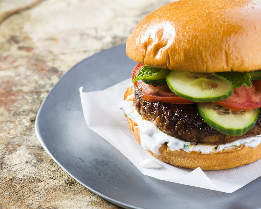 This image released by Milk Street shows a recipe for Indian-spiced pork burgers.. (Milk Street via AP)