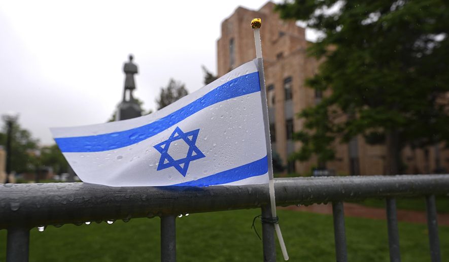 The flag of Israel tops a makeshift memorial for victims of an attack outside of the Boulder County, Colo., courthouse as a light rain falls, June 3, 2025, in Boulder, Colo. (AP Photo/David Zalubowski, File)