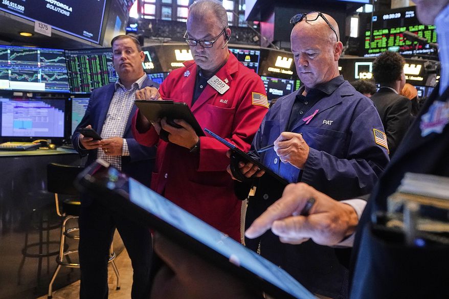 Traders William Lawrence, second left, and Patrick Casey, third left, work on the floor of the New York Stock Exchange, Friday, July 18, 2025. (AP Photo/Richard Drew)