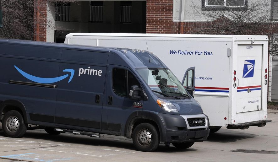 An Amazon Prime truck and a U.S. Postal Service truck make deliveries at an apartment complex in Pittsburgh, Feb. 15, 2024. (AP Photo/Gene J. Puskar, File)