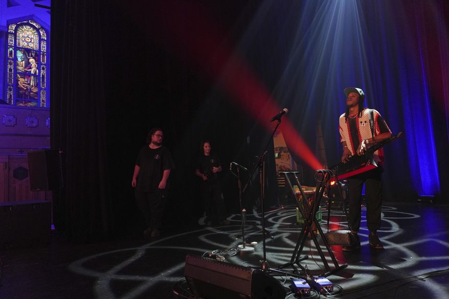 Aboubacar Sinki Kone prepares for a concert with his Kone Kan band at Theatre Paradoxe, a transformed space that was formerly the Notre-Dame-du-Perpetuel-Secours Catholic church in Montreal, Friday, June 27, 2025. (AP Photo/Luis Andres Henao)