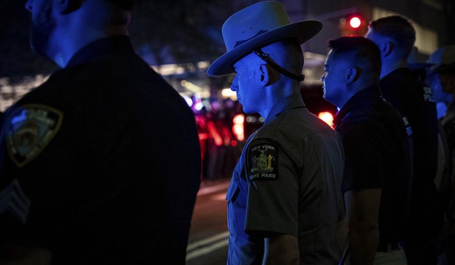 Officers line up during the dignified transfer of Didarul Islam, who was shot and killed by a gunman earlier this evening, out of NewYork-Presbyterian/Weill Cornell Medical Hospital to the medical examiner's office, early Tuesday, July 29, 2025, in New York. (AP Photo/Angelina Katsanis)