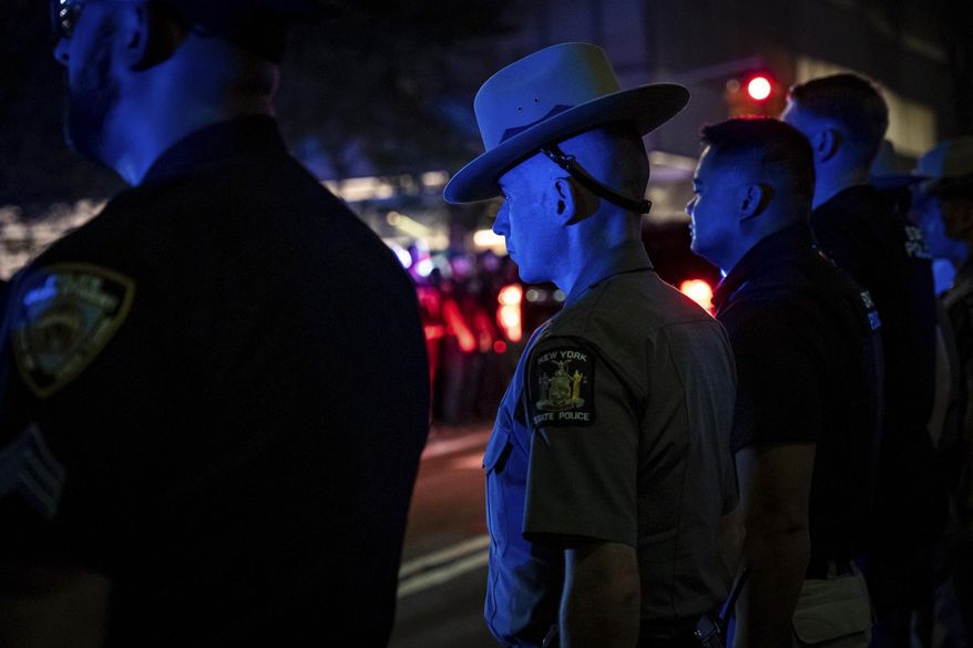 Officers line up during the dignified transfer of Didarul Islam, who was shot and killed by a gunman earlier this evening, out of NewYork-Presbyterian/Weill Cornell Medical Hospital to the medical examiner's office, early Tuesday, July 29, 2025, in New York. (AP Photo/Angelina Katsanis)