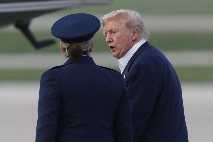 President Donald Trump, right, is escorted by Air Force 89th Air Wing Deputy Commander Melissa Dombrock, left, as he walks from Air Force One before boarding Marine One, upon his arrival at Joint Base Andrews, Md., Tuesday, July 29, 2025. (AP Photo/Luis M. Alvarez) **FILE**