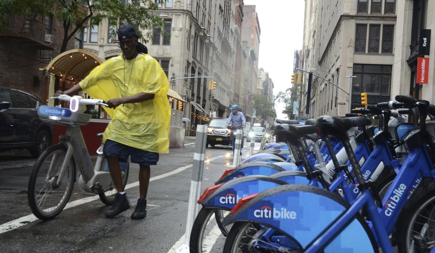 Reggie collects bikes in the rain for Citi Bike to load into a company van on 20th Street and Park Avenue South, Thursday, July 31, 2025, in New York. (AP Photo/Pamela Hassell)