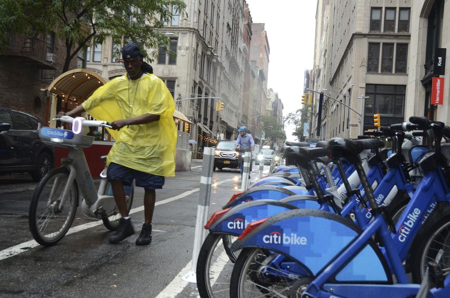 Reggie collects bikes in the rain for Citi Bike to load into a company van on 20th Street and Park Avenue South, Thursday, July 31, 2025, in New York. (AP Photo/Pamela Hassell)
