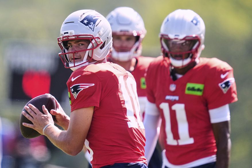 New England Patriots quarterback Drake Maye, left, looks to pass at the team's NFL football training camp, Wednesday, July 30, 2025, in Foxborough, Mass. (AP Photo/Charles Krupa)