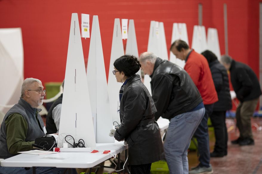 Voters check in to cast ballots in the New Hampshire presidential primary at a polling site in Derry, N.H., on Jan. 23, 2024. (AP Photo/David Goldman) **FILE**