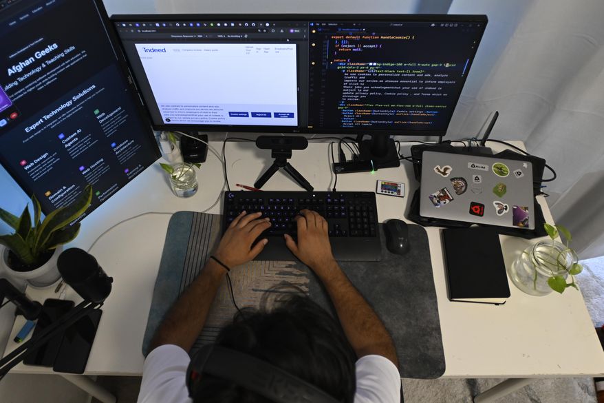 Murtaza Jafari, 25, an Afghan migrant, sits in front of his computer while teaching coding remotely to women currently living in Afghanistan, in Athens, Greece, Wednesday, July 23, 2025. (AP Photo/Michael Varaklas)