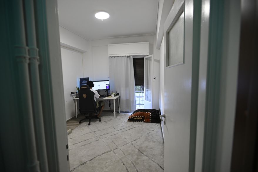 Murtaza Jafari, 25, an Afghan migrant, sits in front of his computer while teaching coding remotely to women currently living in Afghanistan, in Athens, Greece, Wednesday, July 23, 2025. (AP Photo/Michael Varaklas)