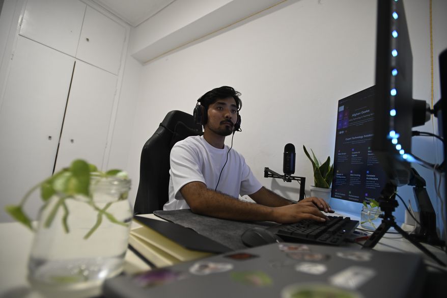 Murtaza Jafari, 25, an Afghan migrant, types code while teaching coding remotely to women currently living in Afghanistan, in Athens, Greece, Wednesday, July 23, 2025. (AP Photo/Michael Varaklas)