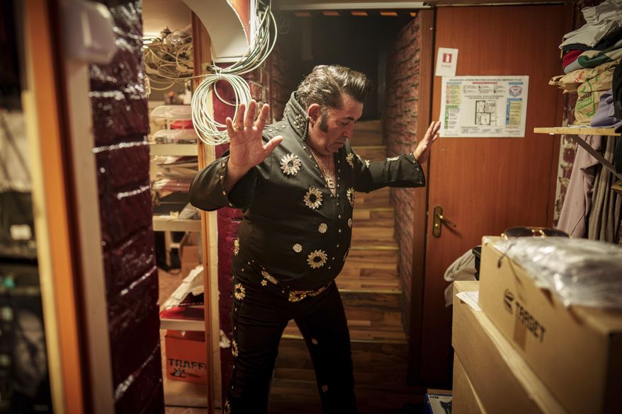 Tudor Lakatos, who goes by the stage name Elvis Rromano, strikes a pose while getting ready for his performance with the Taraful Frunzelor band at the Terasa Florilor restaurant, in Bucharest, Romania, Friday, June 20, 2025. (AP Photo/Vadim Ghirda)