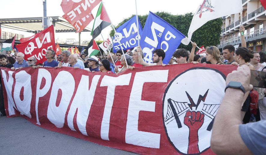 People hold a banner during a demonstration against the bridge in Messina, Italy on Saturday, Aug. 9, 2025 (Francesco Saya/LaPresse via AP)