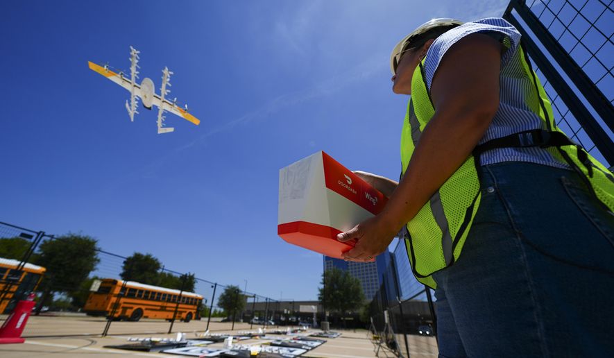 Masslie Arias, of DoorDash, prepares to load a delivery package on a hovering drone Thursday, July 31, 2025, in Frisco, Texas. (AP Photo/Julio Cortez)