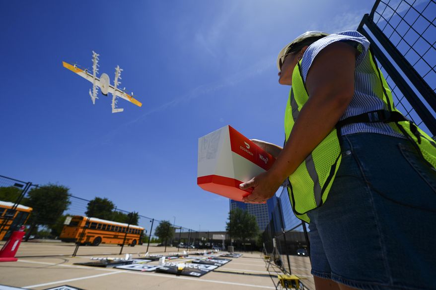 Masslie Arias, of DoorDash, prepares to load a delivery package on a hovering drone Thursday, July 31, 2025, in Frisco, Texas. (AP Photo/Julio Cortez)