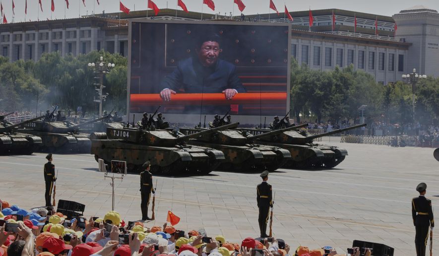 Chinese President Xi Jinping is displayed on a screen as Type 99A2 Chinese battle tanks take part in a parade commemorating the 70th anniversary of Japan's surrender during World War II held in front of Tiananmen Gate in Beijing, on Sept. 3, 2015. (AP Photo/Ng Han Guan, File)
