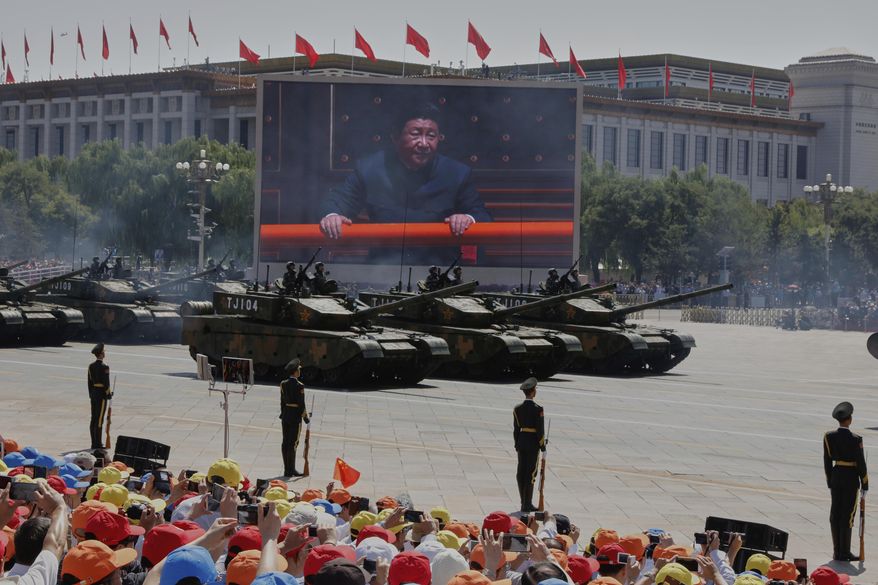 Chinese President Xi Jinping is displayed on a screen as Type 99A2 Chinese battle tanks take part in a parade commemorating the 70th anniversary of Japan's surrender during World War II held in front of Tiananmen Gate in Beijing, on Sept. 3, 2015. (AP Photo/Ng Han Guan, File)