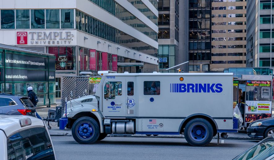 A Philadelphia street during rush hour with people walking, trucks and cars. Brinks armored vehicle. File photo credit: LapaiIrKrapai via Shutterstock.