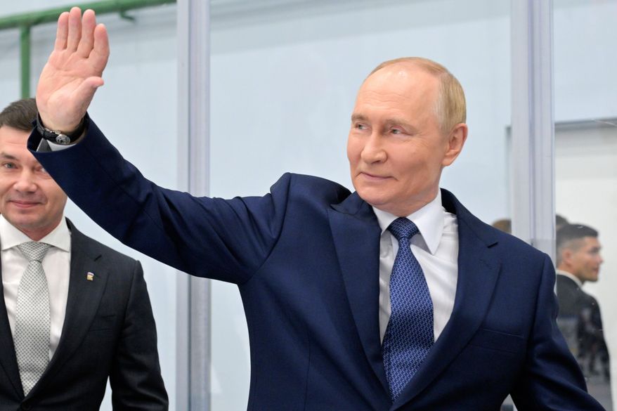 Russian Prime Minister Vladimir Putin waves while visiting the Omega Sea plant in Magadan, about 6,000 kilometers (3,700 miles) east of Moscow, Russia's Far East, on Friday, Aug. 15, 2025, on the way to Alaska. (Alexei Nikolsky, Sputnik, Kremlin Pool Photo via AP)