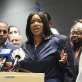 Rep. Jasmine Crockett, D-Texas, center, surrounded by other Democratic members of Congress and Texas House Democrats, speaks during a press conference at the Democratic Party in Warrenville, Ill., Monday, Aug. 4, 2025. (AP Photo/Nam Y. Huh)