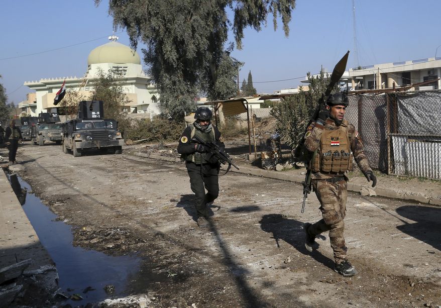 FILE - Iraqi special forces troops advance during a battle against Islamic State militants in Andalus neighborhood in the eastern side of Mosul, Iraq. Iraq, Monday, Jan. 16, 2017. Iraqi officials have begun excavation of what is believed to be a mass grave left behind by the Islamic State extremist group during its rampage across the country a decade ago. (AP Photo/Khalid Mohammed, File)