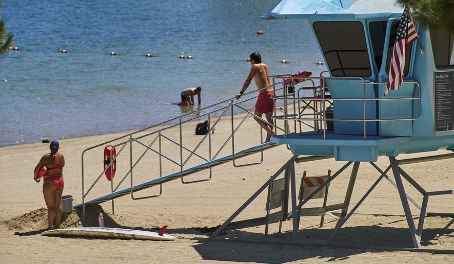 Los Angeles County lifeguards stand on guard as people cool off at Castaic Lake on Wednesday, Aug. 20, 2025, in Castaic, Calif. (AP Photo/Damian Dovarganes)