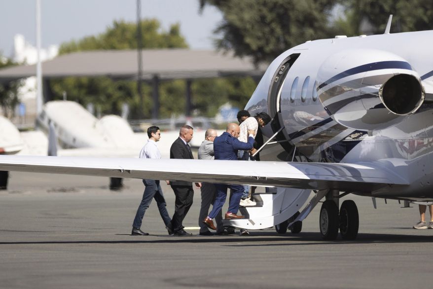 Harjinder Singh is escorted to an airplane by Florida Lt. Gov. Jay Collins and law enforcement on Thursday, Aug. 21, 2025, in Stockton, Calif. (AP Photo/Benjamin Fanjoy)