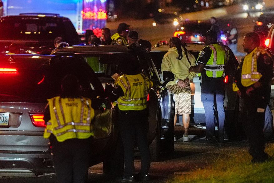 Washington Metropolitan Police Department special operations division officers arrest a person during a traffic checkpoint on New York Avenue in northeast Washington, Wednesday, Aug. 20, 2025. (AP Photo/Julia Demaree Nikhinson)
