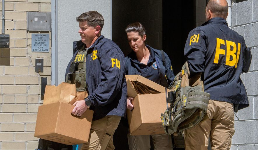 FBI agents carry boxes from former National Security Advisor John Bolton's office in Washington, Friday, Aug. 22, 2025. (AP Photo/Rod Lamkey, Jr.)