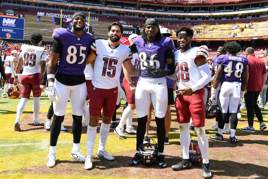 Baltimore Ravens tight end Scotty Washington (85), Washington Commanders quarterback Sam Hartman (15), Baltimore Ravens wide receiver Jahmal Banks (86) and Washington Commanders cornerback Essang Bassey (38) on the field after the end of an NFL preseason game at Northwest Stadium in Landover, MD, August 23, 2025. (Photo for the Washington Times)
