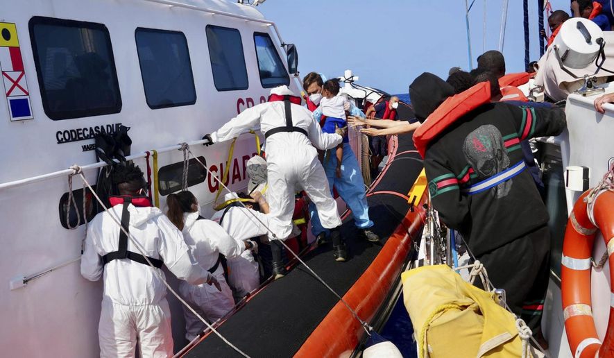 In this photo provided by RESQSHIP, Italian Coast Guard personnel evacuate migrants from the vessel NADIR operated by the organization RESQSHIP, off the coast of the Sicilian Island of Lampedusa, Saturday, Aug. 23, 2025. (Jan Salmen/RESQSHIP via AP)