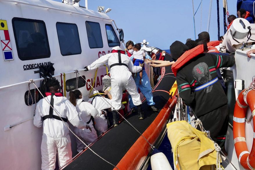 In this photo provided by RESQSHIP, Italian Coast Guard personnel evacuate migrants from the vessel NADIR operated by the organization RESQSHIP, off the coast of the Sicilian Island of Lampedusa, Saturday, Aug. 23, 2025. (Jan Salmen/RESQSHIP via AP)