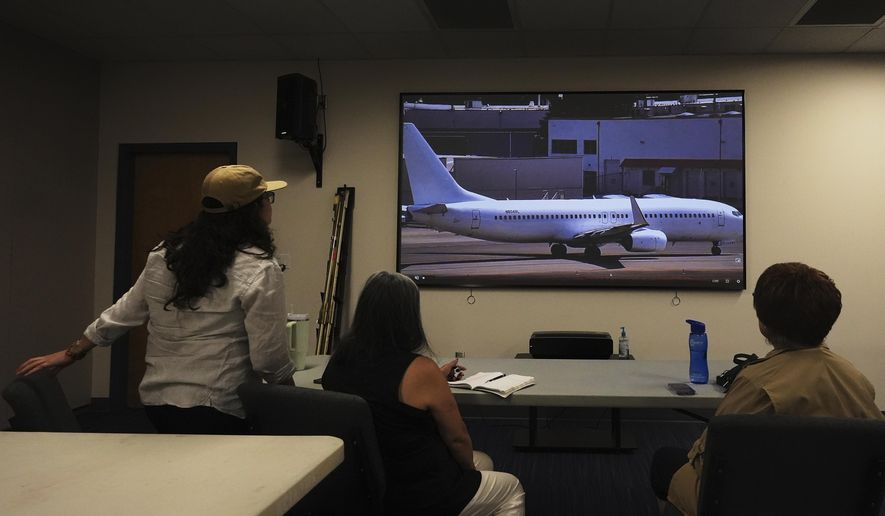 Immigrant rights advocates monitor a webcam available to the public showing a U.S. Immigration and Customs Enforcement flight departing from King County International Airport-Boeing Field, Tuesday, Aug. 19, 2025, in Seattle. (AP Photo/Lindsey Wasson)