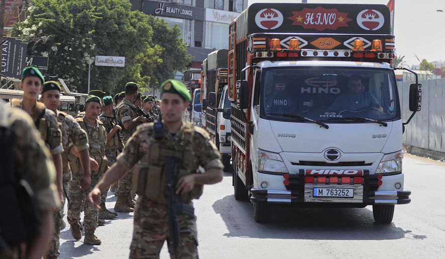Lebanese army soldiers escort trucks carrying weapons handed over by Palestinian factions from Rashidiyeh refugee camp to the Lebanese army, as they pass in Tyre city, south Lebanon, Thursday, Aug. 28, 2025. (AP Photo/Mohammed Zaatari)