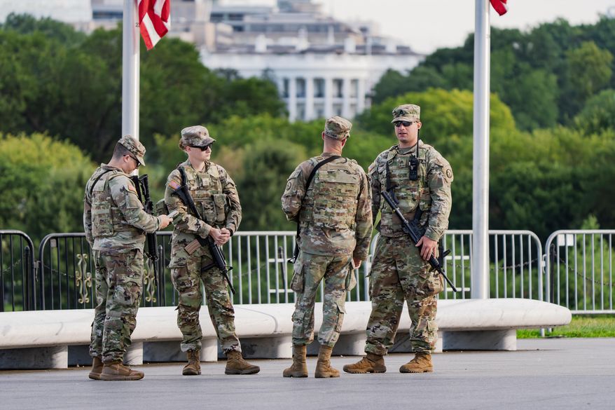 With the White House in the distance, National Guard troops patrol the Mall as part of President Donald Trump's order to impose federal law enforcement in the nation's capital, in Washington, Thursday, Aug. 28, 2025. (AP Photo/J. Scott Applewhite)