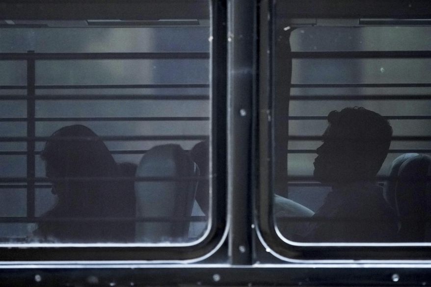 A family from Colombia sits on a bus with tinted and barred windows after they were detained by federal agents following an appearance at immigration court Monday, July 14, 2025, in San Antonio. (AP Photo/Eric Gay) **FILE**