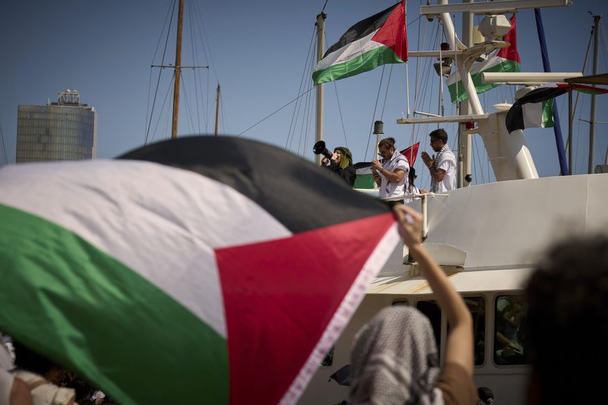 Demonstrators shout slogans on a boat ahead of the launch of a civilian flotilla bound for Gaza, aiming to break the Israeli blockade and deliver humanitarian aid in Barcelona, Spain, Sunday, Aug. 31, 2025. (AP Photo/Emilio Morenatti)