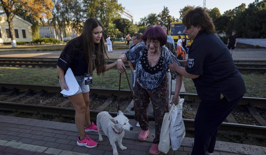 Tetiana Zaichikova, center, walks on a platform during evacuation at the train station in Lozova, Ukraine, Wednesday, Sept. 3, 2025. (AP Photo/Evgeniy Maloletka)