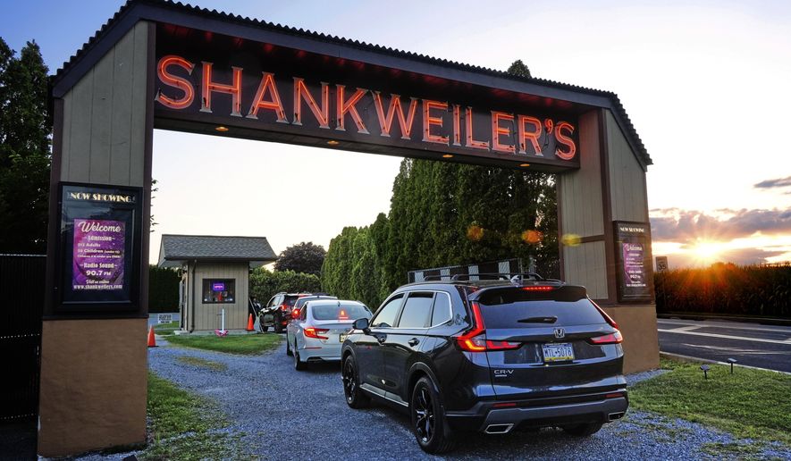 The sun sets on the Shankweiler Drive-In as cars arrive for the evening's double feature of "Jaws" and "Twisters" in Orefield, Pa., Friday, Aug. 29, 2025. (AP Photo/Gene J. Puskar)