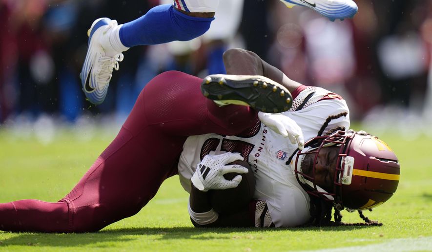Washington Commanders wide receiver Noah Brown (85) falls to the ground with the ball during the second half of an NFL football game against the New York Giants, Sunday, Sept. 7, 2025, in Landover, Md. (AP Photo/Stephanie Scarbrough)
