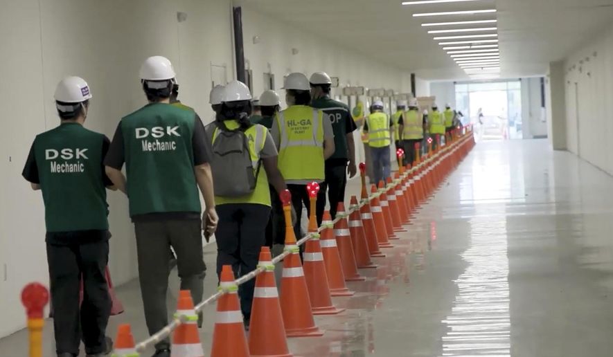 This image from video provided by U.S. Immigration and Customs Enforcement via DVIDS shows manufacturing plant employees being escorted outside the Hyundai Motor Group’s electric vehicle plant, Thursday, Sept. 4, 2025, in Ellabell, Ga. (Corey Bullard/U.S. Immigration and Customs Enforcement via AP)
