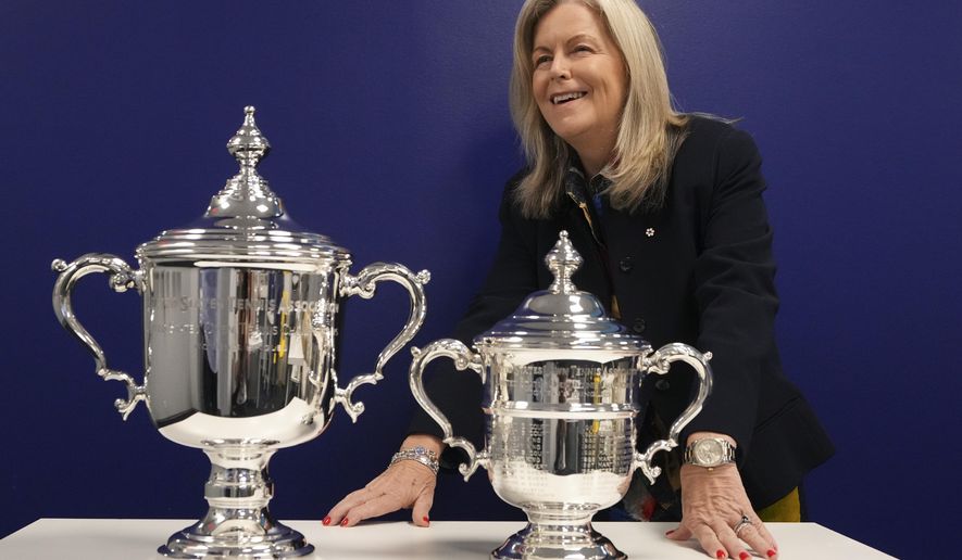 Stacey Allaster, U.S. Open tournament director and chief executive of professional tennis at the U.S. Tennis Association, poses for a photo with the women's keepsake trophy left, and presentation trophy, during an interview at the U.S. Open tennis championships, Wednesday, Sept. 3, 2025, in New York. (AP Photo/Kirsty Wigglesworth)