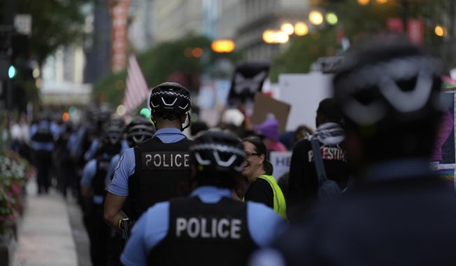Police walk along as people march during Illinois Coalition for Immigrant & Refugee Rights' "Chicago Says No Trump No Troops" protest Saturday, Sept. 6, 2025, in Chicago. (AP Photo/Carolyn Kaster)