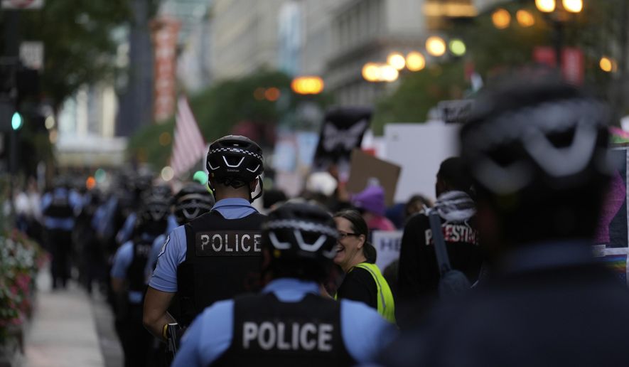 Police walk along as people march during Illinois Coalition for Immigrant & Refugee Rights' "Chicago Says No Trump No Troops" protest Saturday, Sept. 6, 2025, in Chicago. (AP Photo/Carolyn Kaster) ** FILE **