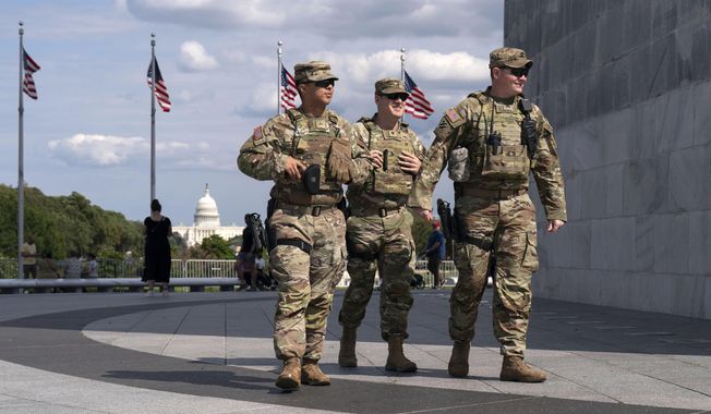 Members of the Louisiana National Guard patrol the grounds of the Washington Monument at the National Mall, Sunday, Sept. 7, 2025, in Washington. (AP Photo/Jose Luis Magana)