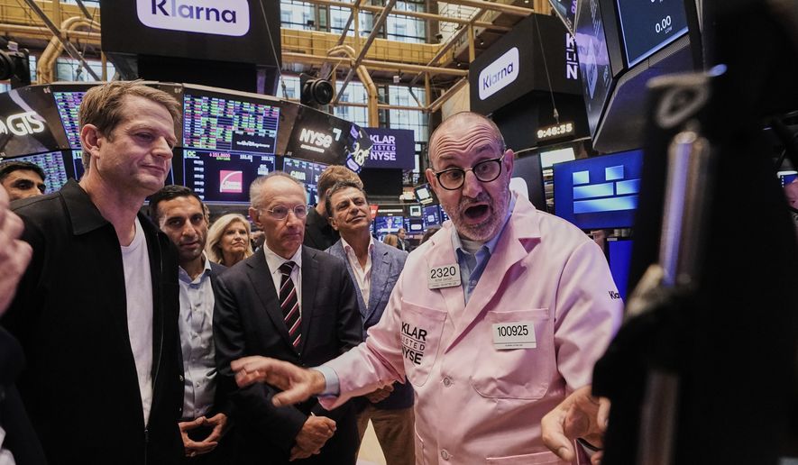 Klarna CEO Sebastian Siemiatkowski, left and company Chairman Michael Moritz, center, meet with specialist Peter Giacchi, right, before their IPO begins trading on the floor of the New York Stock Exchange, Wednesday, Sept. 10, 2025. (AP Photo/Richard Drew)